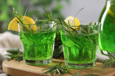 Photo for Refreshing tarragon drink with lemon slices on table, closeup - Royalty Free Image