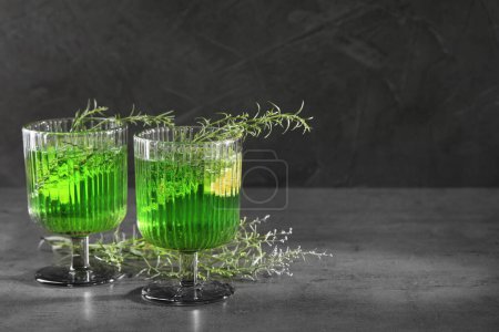 Photo for Glasses of homemade refreshing tarragon drink and sprigs on grey table, space for text - Royalty Free Image
