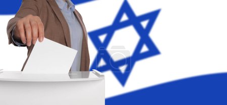 Foto de Mujer poniendo su voto en las urnas contra la bandera nacional de Israel, primer plano. Diseño de banner con espacio para texto - Imagen libre de derechos