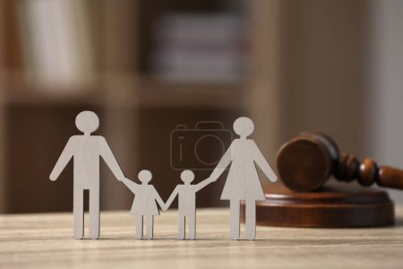 Derecho de familia. Figura de padres con niños y mazo sobre mesa de madera, espacio para texto