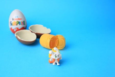 Photo for Slynchev Bryag, Bulgaria - May 25, 2023: Kinder Surprise Eggs, plastic capsule and toy bunny on light blue background, space for text - Royalty Free Image
