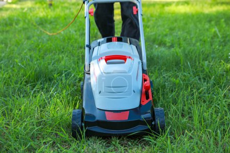 Photo for Man cutting grass with lawn mower in garden, closeup - Royalty Free Image