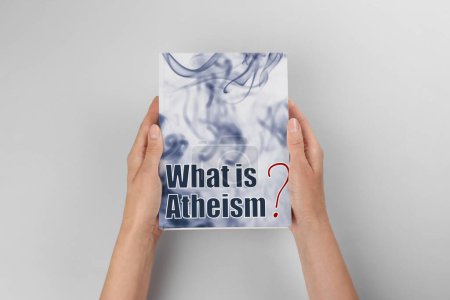 Foto de Mujer sosteniendo libro sobre el ateísmo en el fondo de luz, vista superior - Imagen libre de derechos