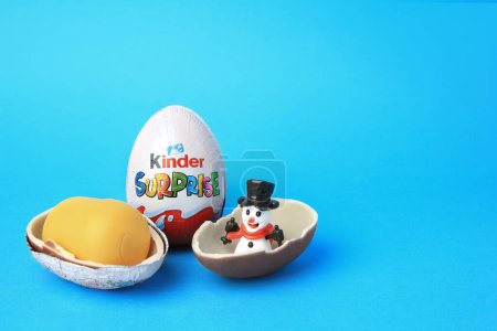 Photo for Slynchev Bryag, Bulgaria - May 25, 2023: Kinder Surprise Eggs, plastic capsule and toy snowman on light blue background, space for text - Royalty Free Image