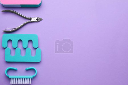 Foto de Conjunto de herramientas de pedicura sobre fondo violeta, planas. Espacio para texto - Imagen libre de derechos