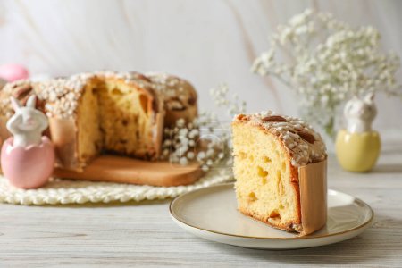 Foto de Delicioso pastel de paloma de Pascua italiana (Colomba di Pasqua tradicional) y decoración festiva en mesa de madera blanca - Imagen libre de derechos