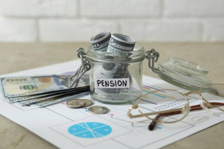 Photo for Glass jar with word Pension, money, chart and glasses on beige table, closeup - Royalty Free Image