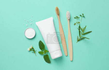 Téléchargez les photos : Composition plate avec brosses à dents et herbes en bambou sur fond turquoise - en image libre de droit