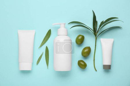 Téléchargez les photos : Produits cosmétiques à l'huile essentielle d'olive sur fond turquoise clair, pose plate - en image libre de droit