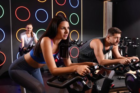 Photo for Group of people training on exercise bikes in fitness club - Royalty Free Image