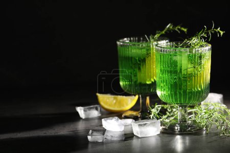 Photo for Glasses of homemade refreshing tarragon drink, ice cubes and sprigs on grey table, space for text - Royalty Free Image