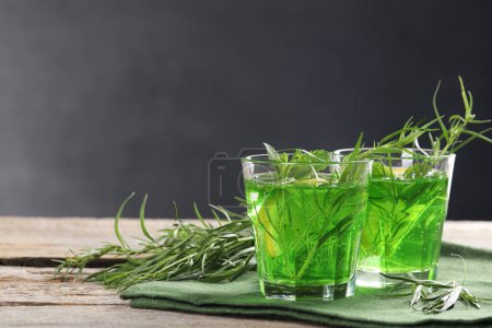 Photo for Glasses of refreshing tarragon drink on wooden table. Space for text - Royalty Free Image