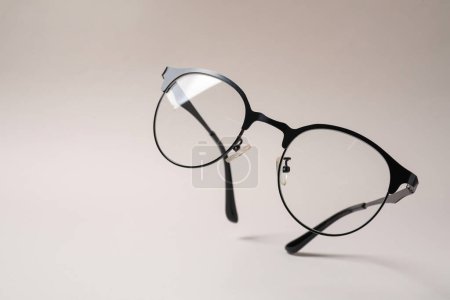 Stylish pair of glasses with black frame on beige background. Space for text