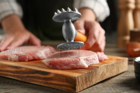 Téléchargez les photos : Schnitzel de cuisine femme à table en bois, mise au point sélective - en image libre de droit
