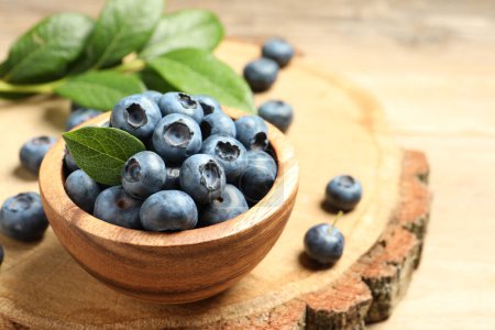 Bowl of fresh tasty blueberries on table, closeup. space for text