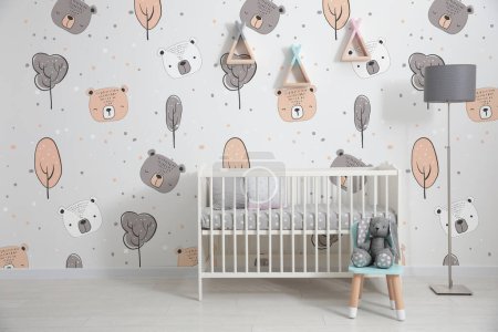 Modernes Interieur für Babys mit komfortablem Kinderbett in Fensternähe und niedlichen Tapeten
