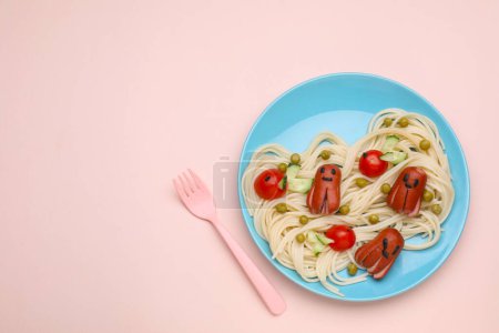 Foto de Servicio creativo para niños. Placa con lindos pulpos hechos de salchichas, pasta y verduras sobre mesa rosa, puesta plana. Espacio para texto - Imagen libre de derechos