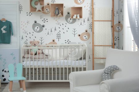 Téléchargez les photos : Élégant intérieur de chambre de bébé avec berceau, fauteuil et fonds d'écran mignon - en image libre de droit