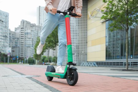 Photo for Man riding modern electric kick scooter on city street, closeup - Royalty Free Image