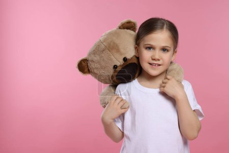 Téléchargez les photos : Jolie fille avec ours en peluche sur fond rose, espace pour le texte - en image libre de droit