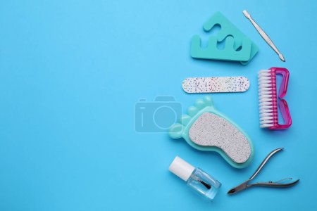 Foto de Juego de herramientas de pedicura sobre fondo azul claro, plano. Espacio para texto - Imagen libre de derechos