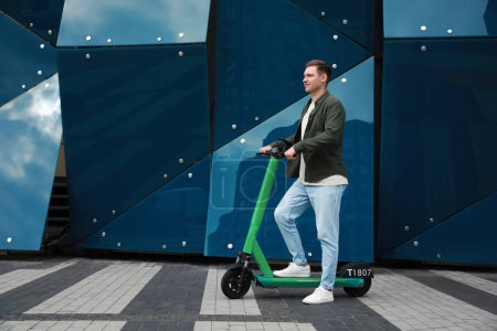 Photo for Happy man with modern electric kick scooter on city street, space for text - Royalty Free Image