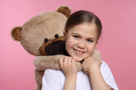 Téléchargez les photos : Jolie fille avec ours en peluche sur fond rose - en image libre de droit