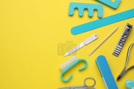 Foto de Juego de herramientas de pedicura sobre fondo amarillo, plano. Espacio para texto - Imagen libre de derechos