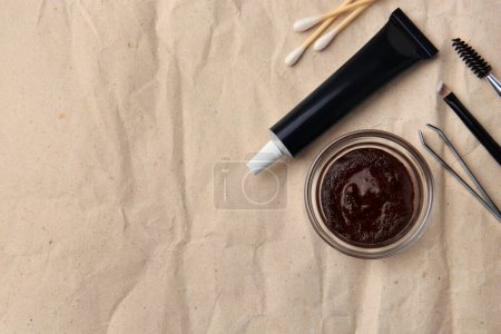 Téléchargez les photos : Composition à plat avec henné des sourcils et outils sur papier froissé. Espace pour le texte - en image libre de droit