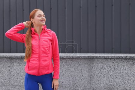 Photo for Beautiful woman in gym clothes on street, space for text - Royalty Free Image