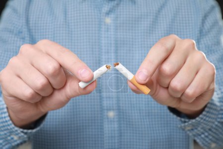 Rauchstopp-Konzept. Mann mit zerbrochenen Zigarettenstücken, Nahaufnahme