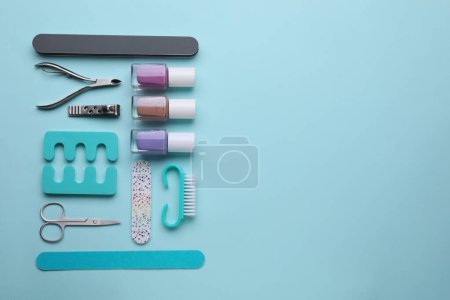 Foto de Juego de herramientas de pedicura sobre fondo azul claro, plano. Espacio para texto - Imagen libre de derechos