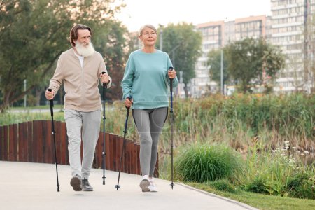 Photo for Senior man and woman performing Nordic walking outdoors, space for text - Royalty Free Image