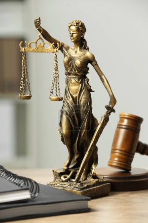 Téléchargez les photos : Figure de Lady Justice, marteau et cahiers sur table en bois à l'intérieur. Symbole du traitement équitable prévu par la loi - en image libre de droit