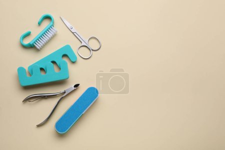 Foto de Conjunto de herramientas de pedicura sobre fondo beige, planas. Espacio para texto - Imagen libre de derechos