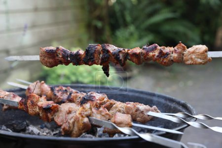 Photo for Cooking delicious kebab on metal skewers outdoors - Royalty Free Image
