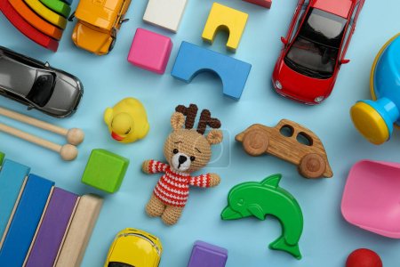 Different children's toys on light blue background, flat lay