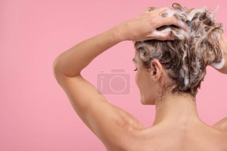Foto de Mujer lavando el cabello sobre fondo rosa, vista trasera. Espacio para texto - Imagen libre de derechos
