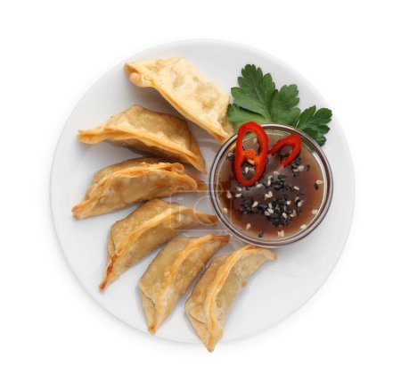 Téléchargez les photos : Délicieux gyoza (boulettes asiatiques) avec sauce soja, poivre, persil et sésame isolé sur blanc, vue de dessus - en image libre de droit