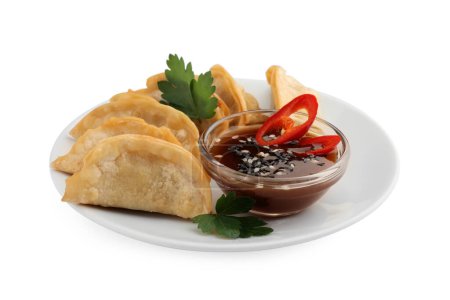 Téléchargez les photos : Délicieux gyoza (boulettes asiatiques) à la sauce soja, poivre, persil et sésame isolé sur blanc - en image libre de droit