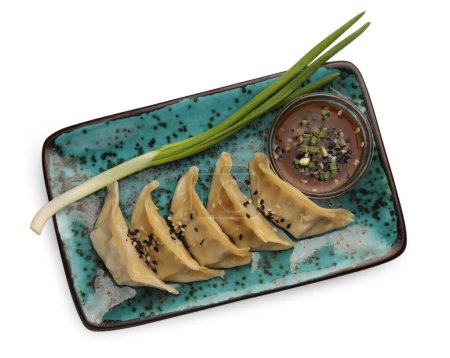 Téléchargez les photos : Délicieux gyoza (boulettes asiatiques) avec sauce, oignon et sésame isolé sur blanc, vue de dessus - en image libre de droit