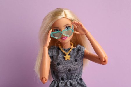 Foto de Mykolaiv, Ucrania - 4 de septiembre de 2023: Hermosa muñeca Barbie con gafas con estilo sobre fondo lila - Imagen libre de derechos