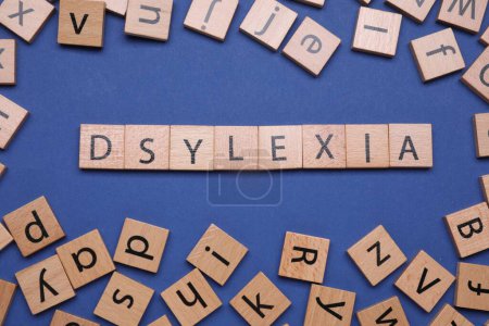Téléchargez les photos : Mot Dyslexie faite avec des cubes mélangés sur fond bleu, plat laïc - en image libre de droit