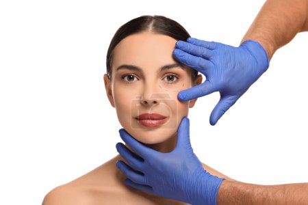 Arzt überprüft Gesicht des Patienten vor Schönheitschirurgie-Operation auf weißem Hintergrund