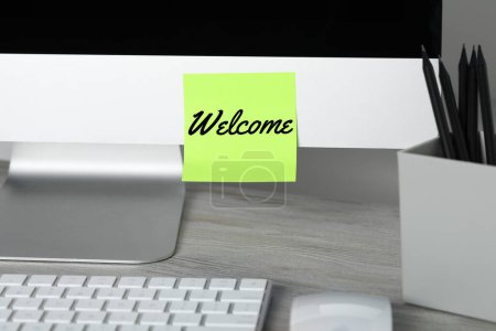 Téléchargez les photos : Note collante avec mot Bienvenue sur l'écran d'ordinateur dans le bureau - en image libre de droit