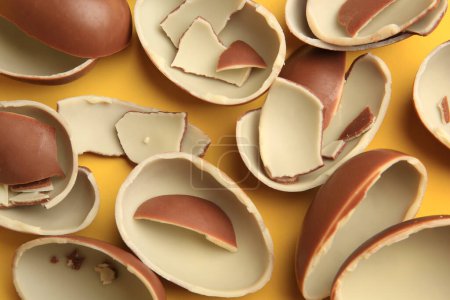 Photo for Sveti Vlas, Bulgaria - July 3, 2023: Broken halves of Kinder Surprise Eggs on yellow background, flat lay - Royalty Free Image