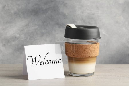 Téléchargez les photos : Note de papier avec mot Bienvenue et tasse de café sur la table - en image libre de droit