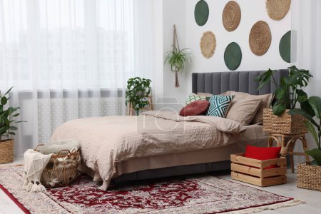 Foto de Gran cama cómoda y plantas de interior macetas en el dormitorio con estilo. Diseño de interiores - Imagen libre de derechos