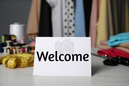 Téléchargez les photos : Carnet avec phrase Bienvenue Retour et accessoires de couture sur la table - en image libre de droit
