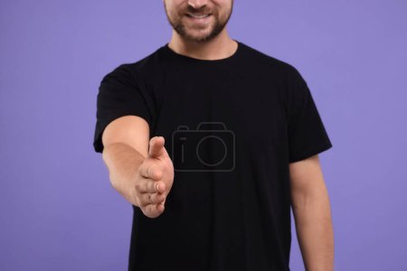 Téléchargez les photos : Homme accueillant et offrant poignée de main sur fond violet, gros plan - en image libre de droit